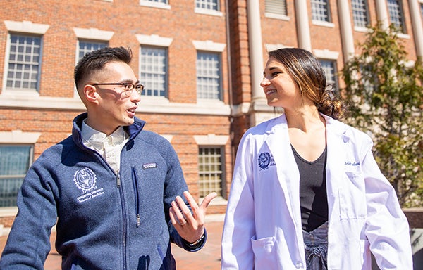 Two medical students walk together outdoors