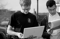 Two volunteers check laptops