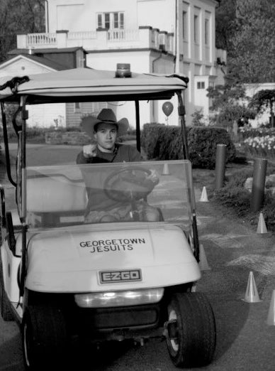 A volunteer driving a golf cart points at the camera