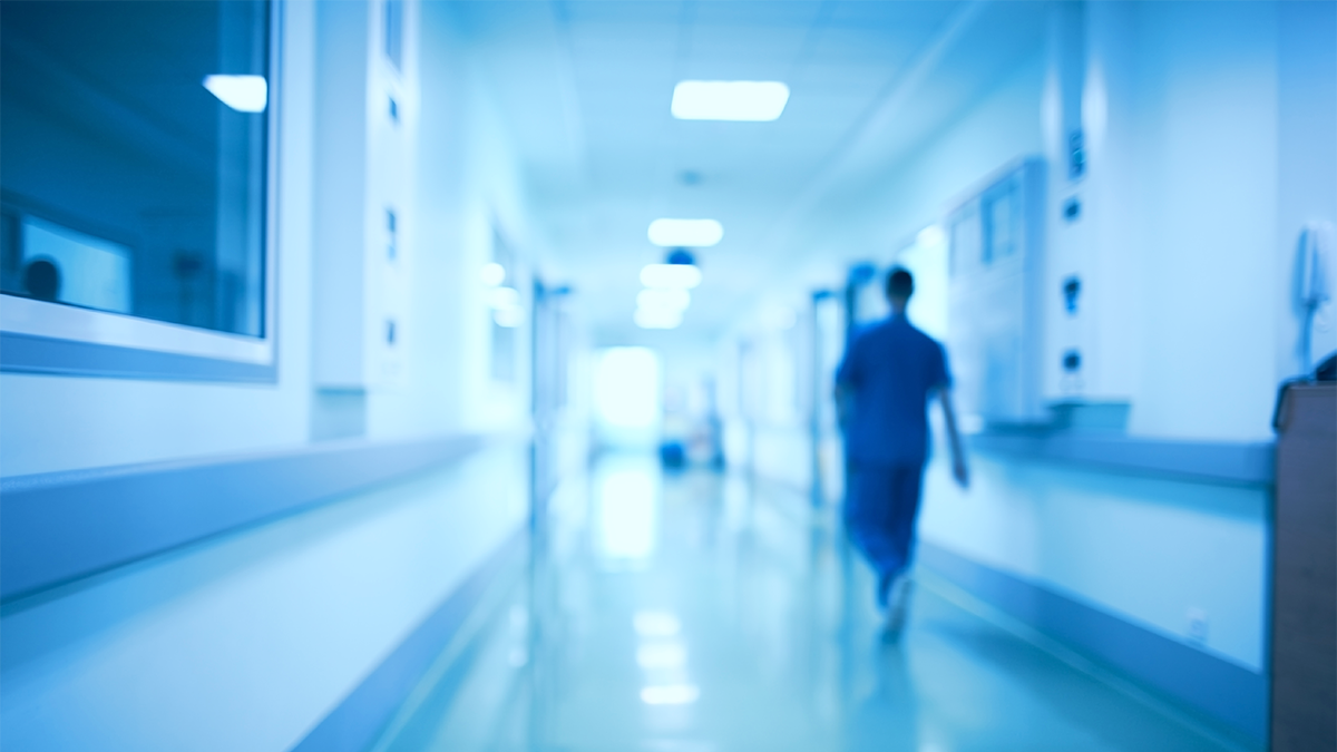 A person walks down the hallway of a hospital