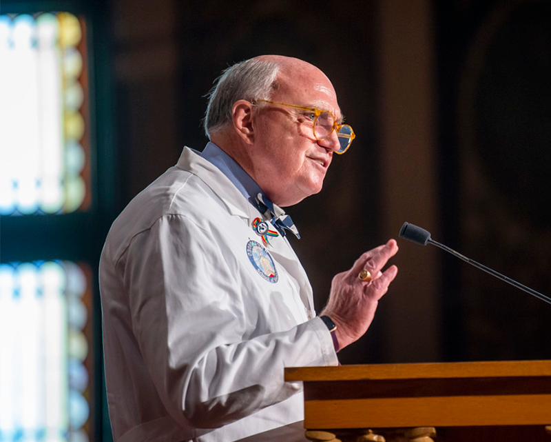 Stephen R. Mitchell speaks from a podium during the White Coat ceremony