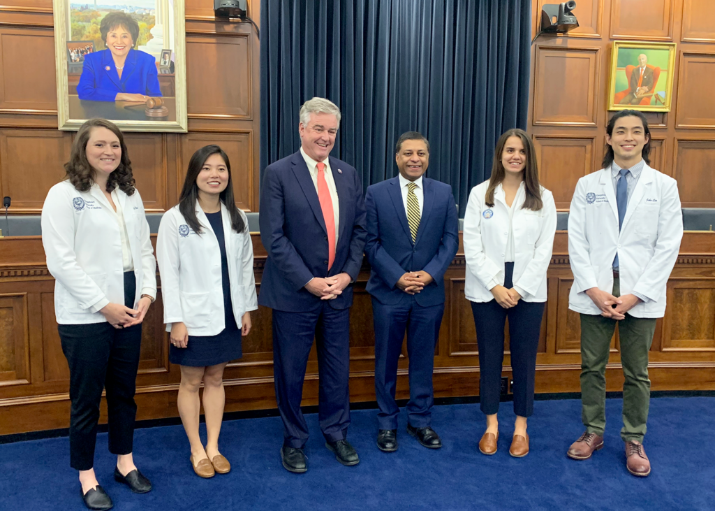 Four medical students stand with two Congressional staffers in a group