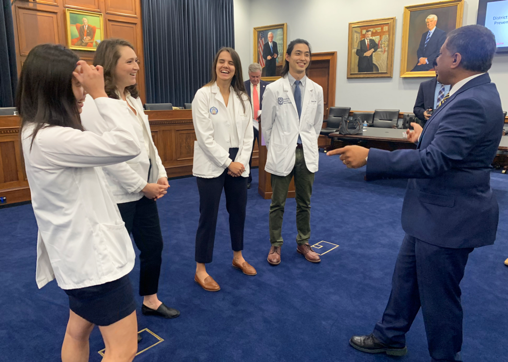 Four students meet with a Congressional staffer in an official office