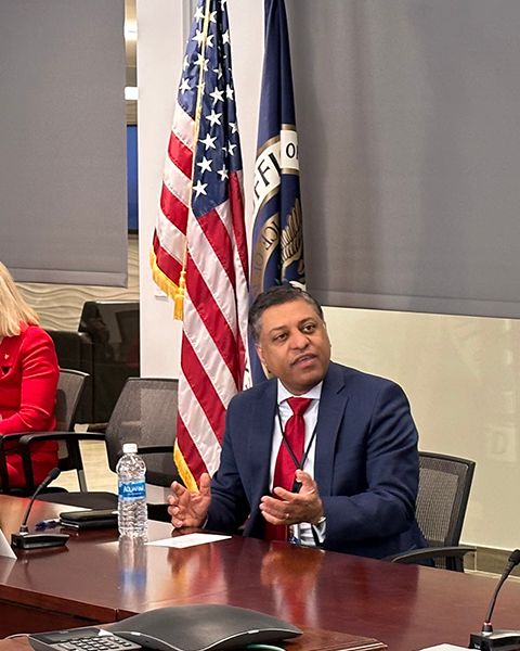 Rahul Gupta speaks while seated at a table