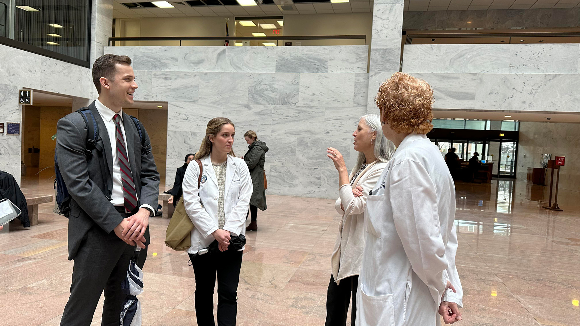 Four people stand in the lobby of a Capitol Hill building