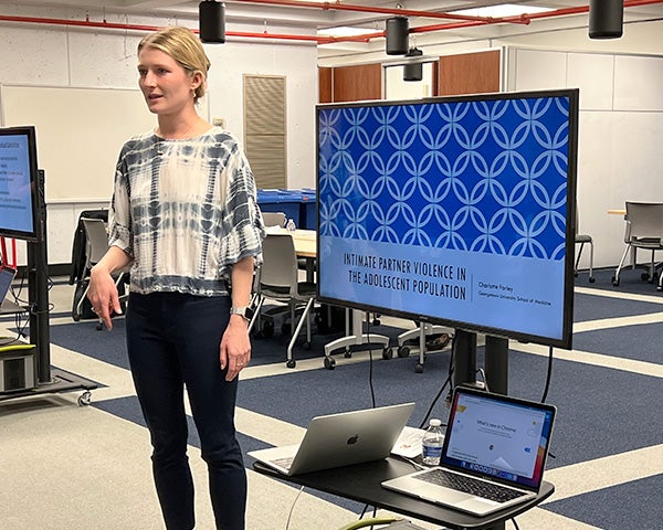 Charlotte Farley stands before a monitor display of her project 