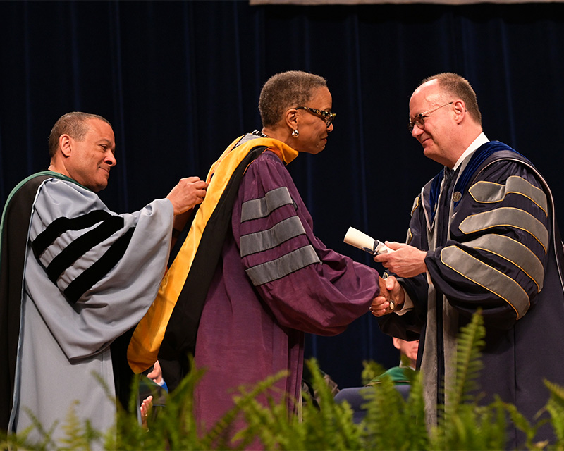Dean Jones and President DeGioia present Dr. Reede with her honorary degree