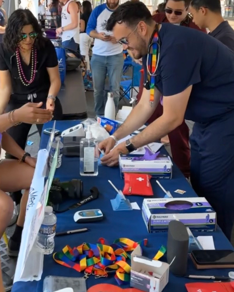 Students assist Pride Festival attendees coming to their table for screenings
