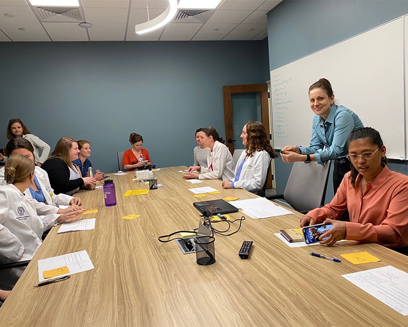 Students sit around a table working on an activity together