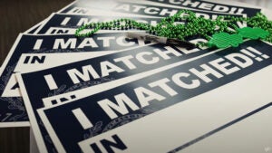 blank signs that read I Matched! sit on a table with markers and St. Patrick's Day decorations