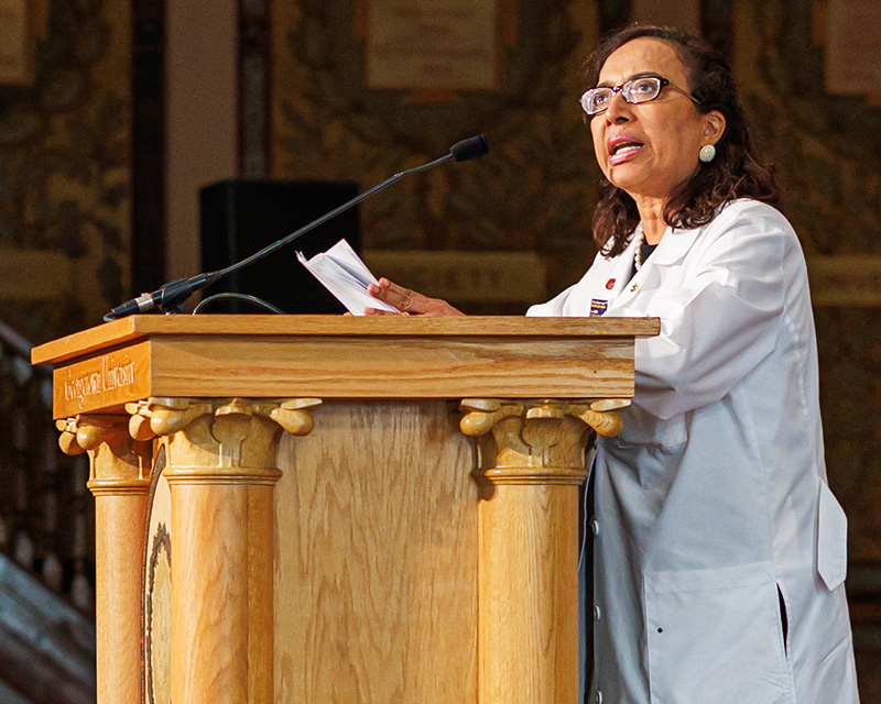 Dr. Princy Kumar speaks from a podium onstage in Gaston Hall