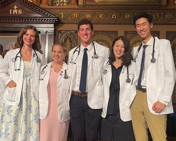 A group of medical students stands together at their White Coat Ceremony