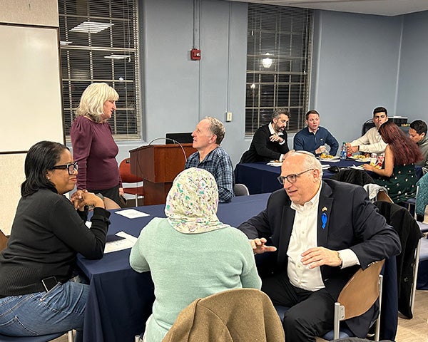 A table of faith leaders converses during the meal