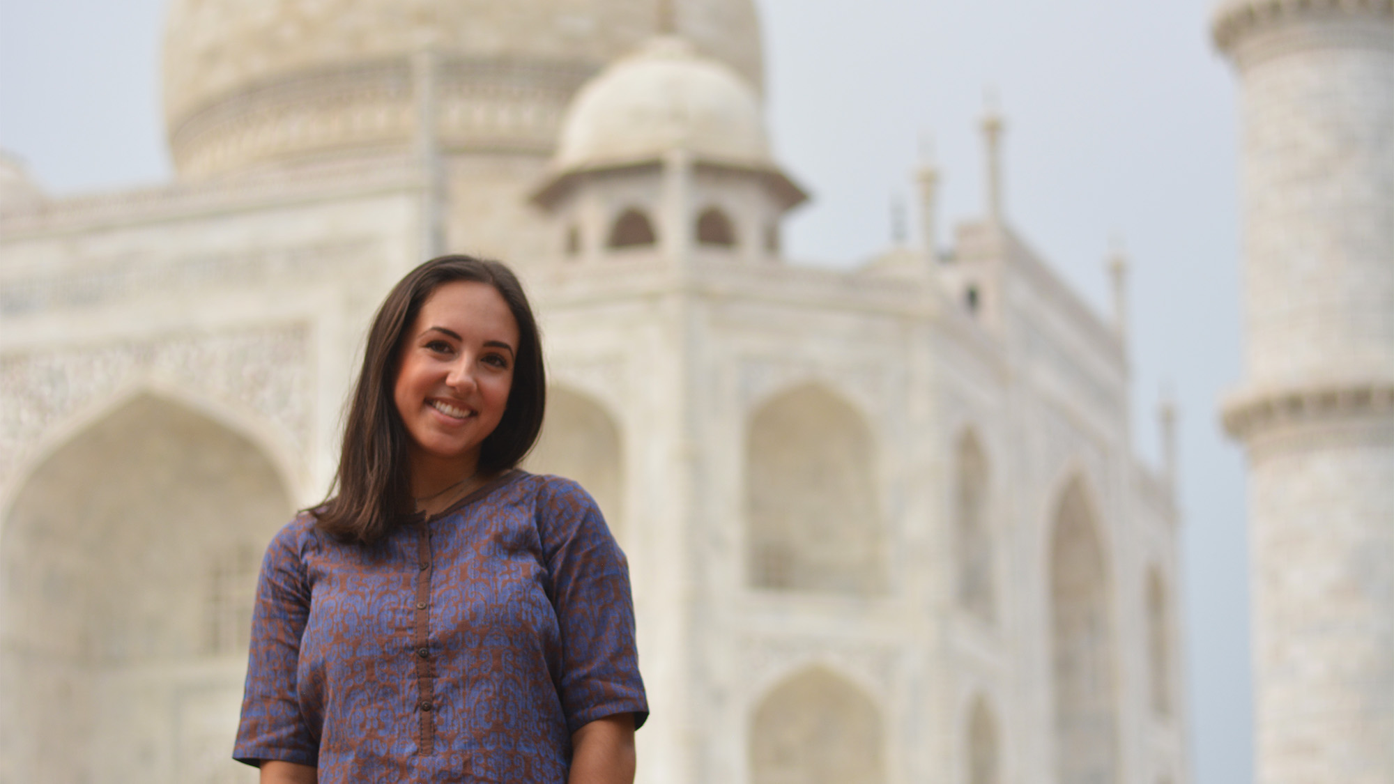 Amanda Wibben stands with a temple in India in the background