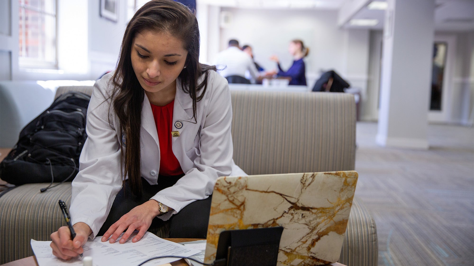 A medical student studies at her computer in a common area on campus