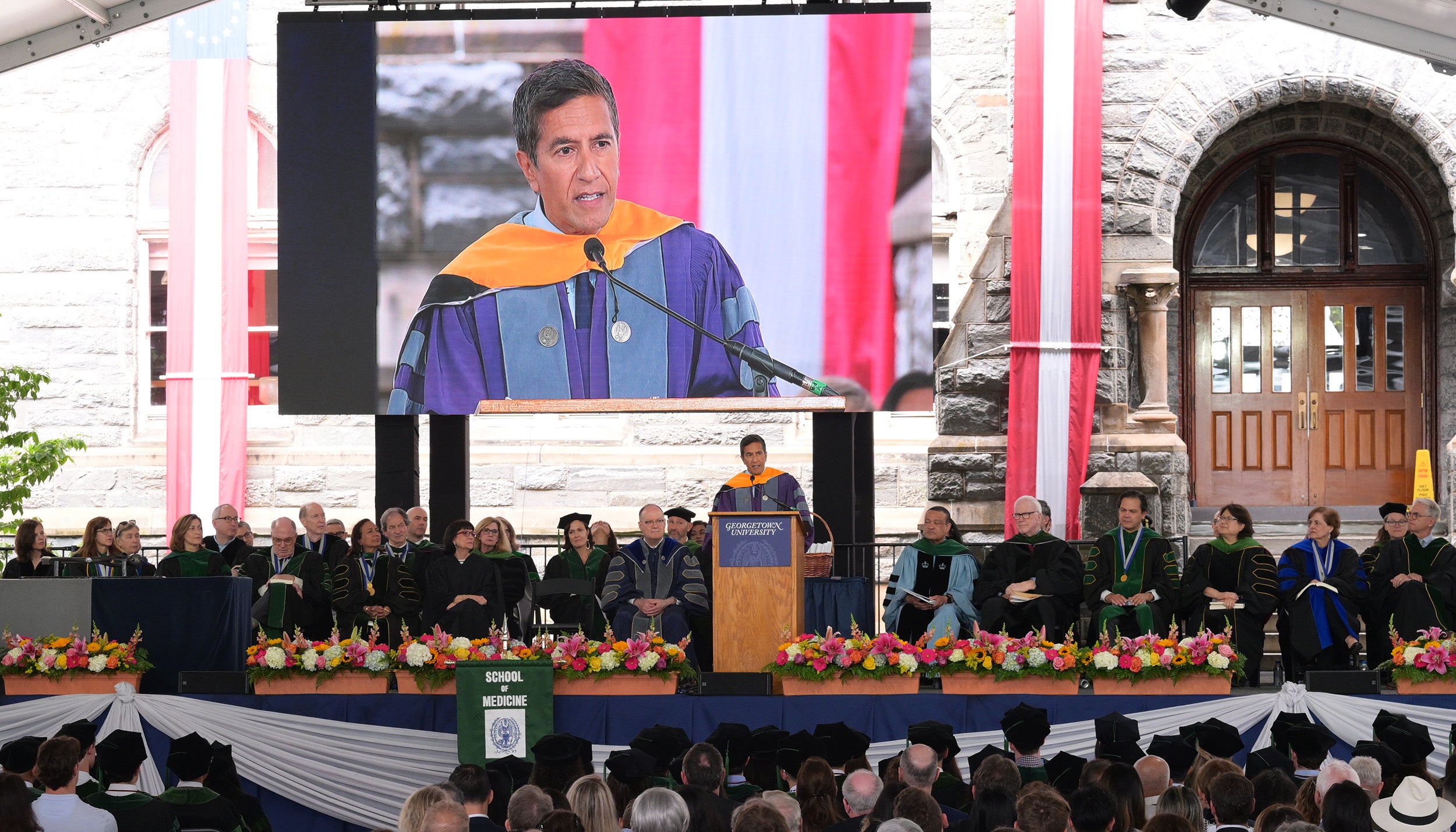 Sanjay Gupta speaks from a podium onstage at the School of Medicine commencement ceremony