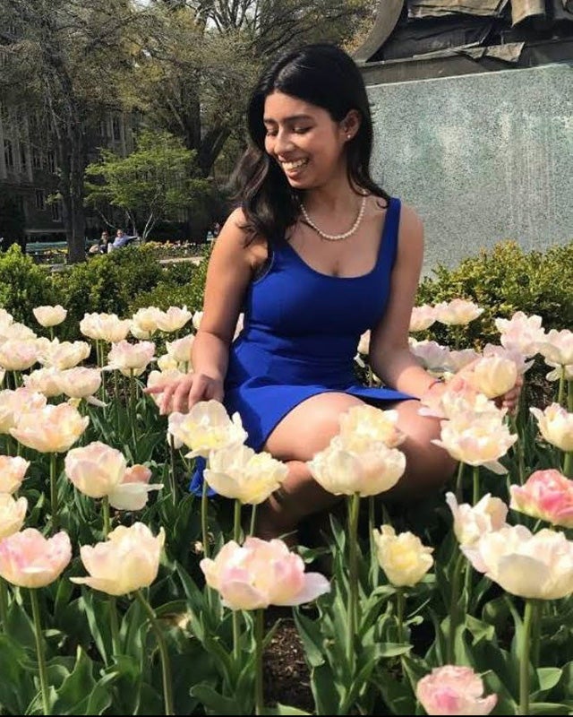 Diaz amid tulips at the base of the John Carroll statue on Georgetown's campus