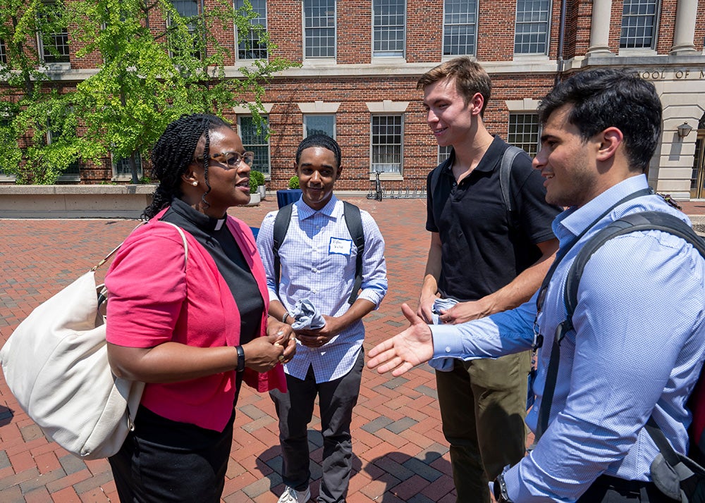 Rev. Ebony Grisom speaks with three students