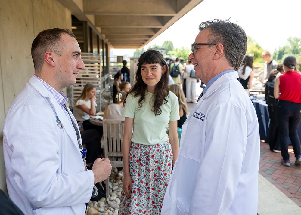 Norm Beauchamp talks with organizers Abigail Escobar and John DiBello