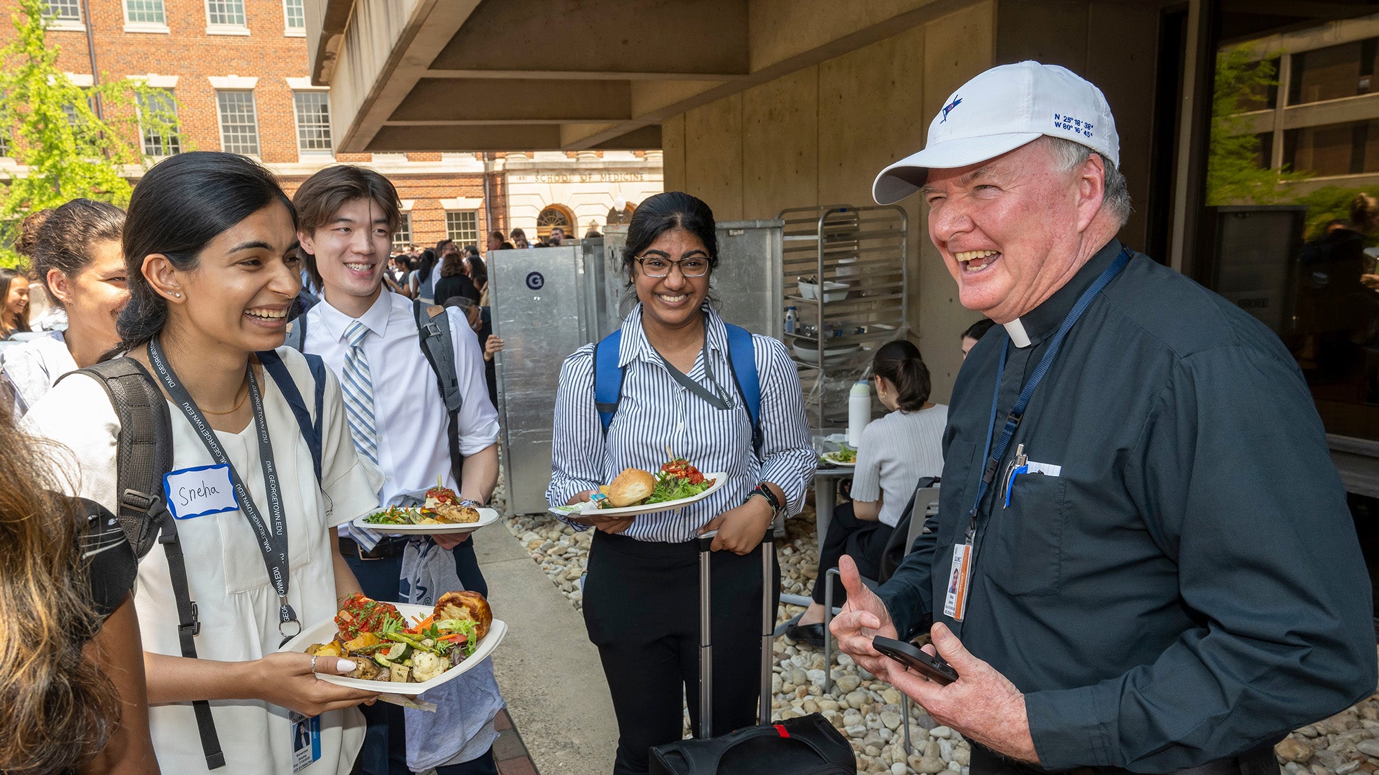 Students and Father Shea share a moment of levity at the interfaith welcome luncheon