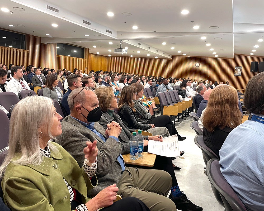 An auditorium is filled with people seated in rows