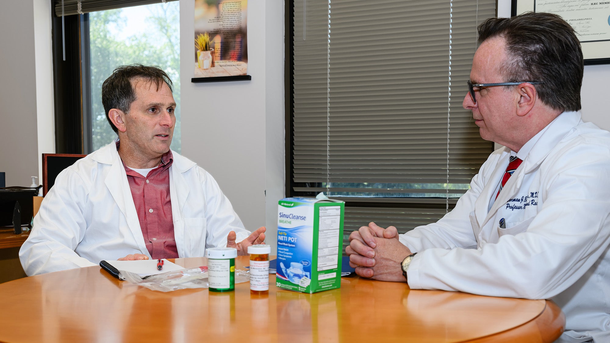 Dr. Beauchamp and Dr. Merenstein sit at a table talking