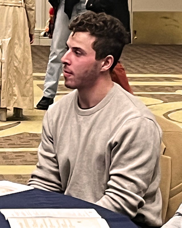 Ryan Broun sits at a table at the Interfaith Dinner