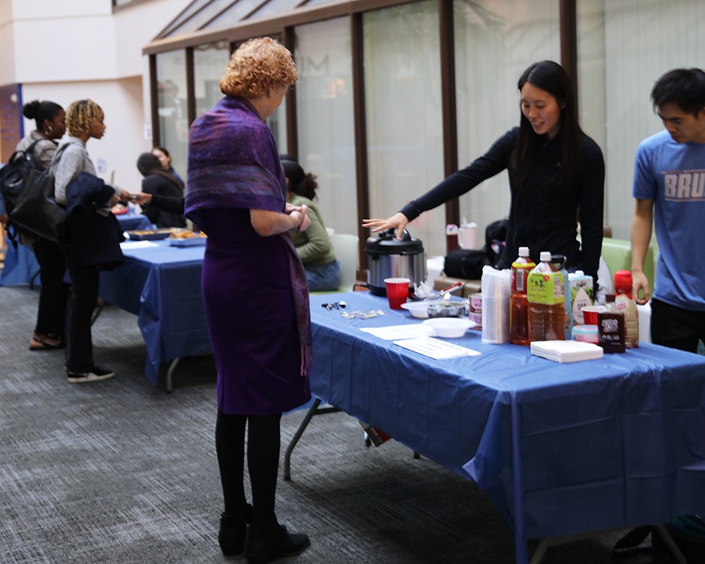 Two students explain their table to Eileen Moore