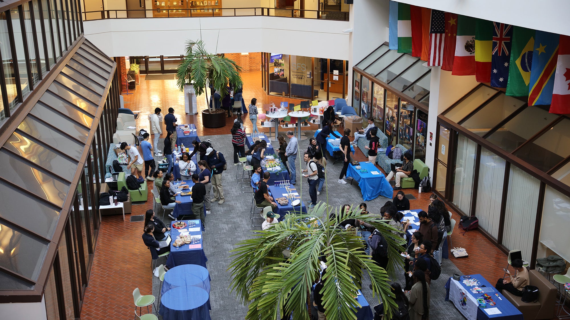 A view of the event from above showing tables with students milling around them