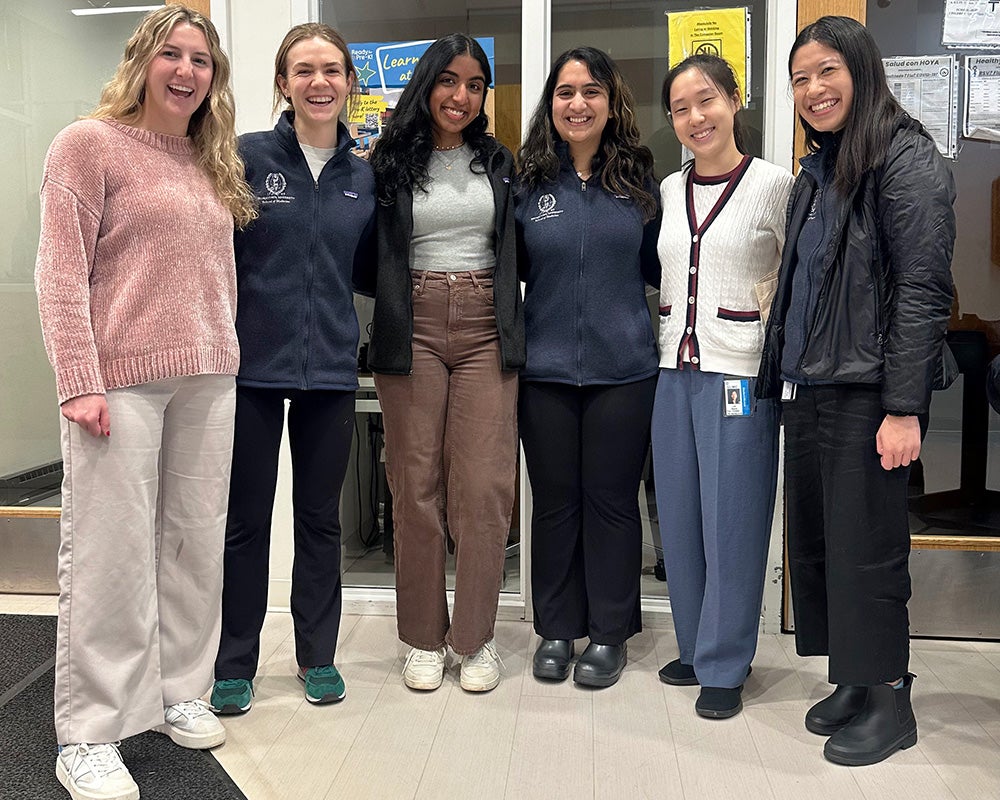 Six students stand together