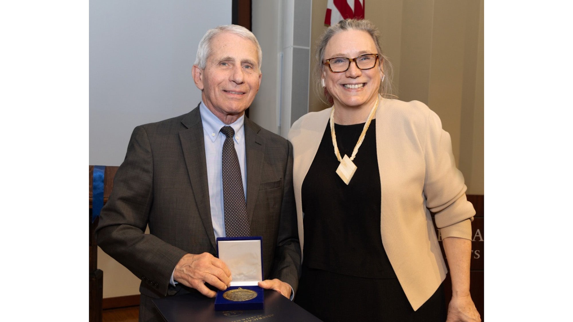 Laurie L. Patton stands next to Anthony S. Fauci who is holding a blue box with his award, which is a circular-shaped gold-colored medallion