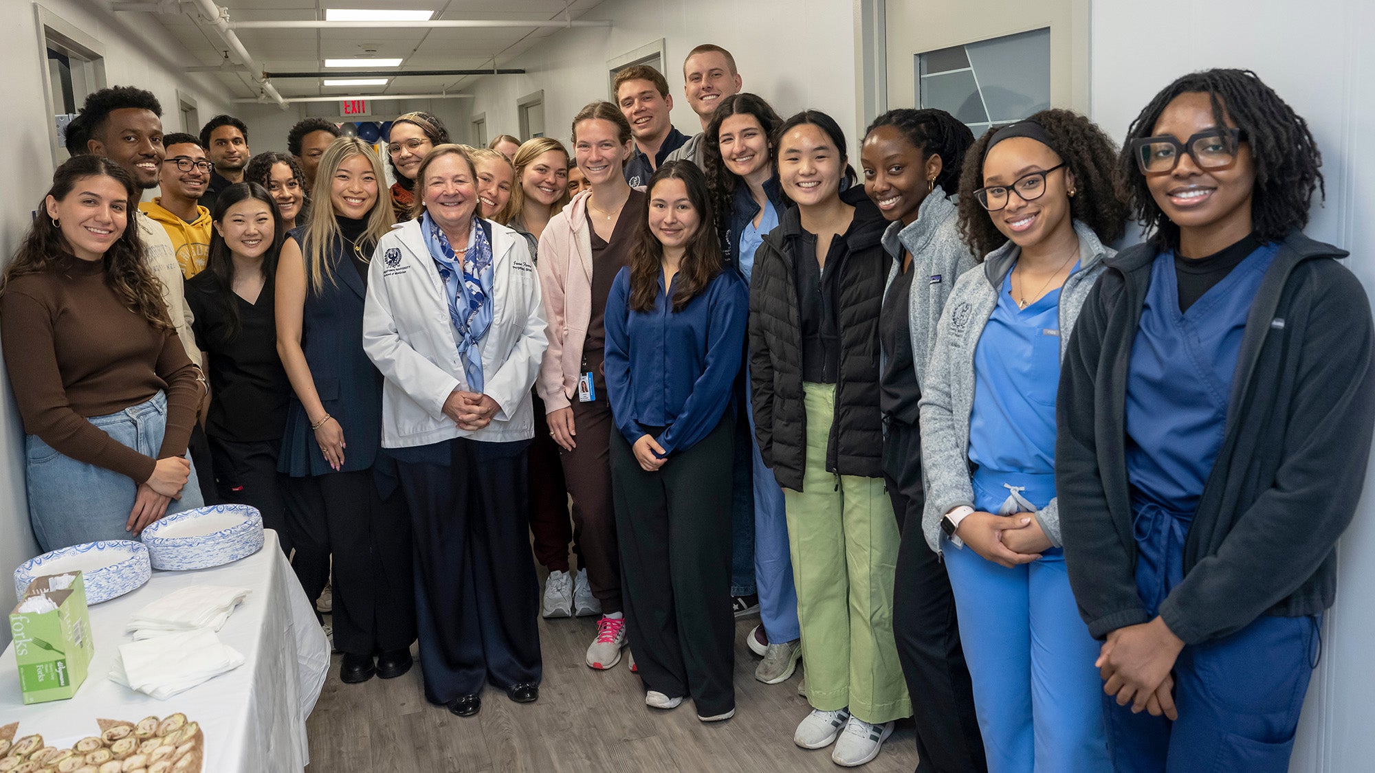 Joan Ferril stands with a large group of medical students in the annex hallway